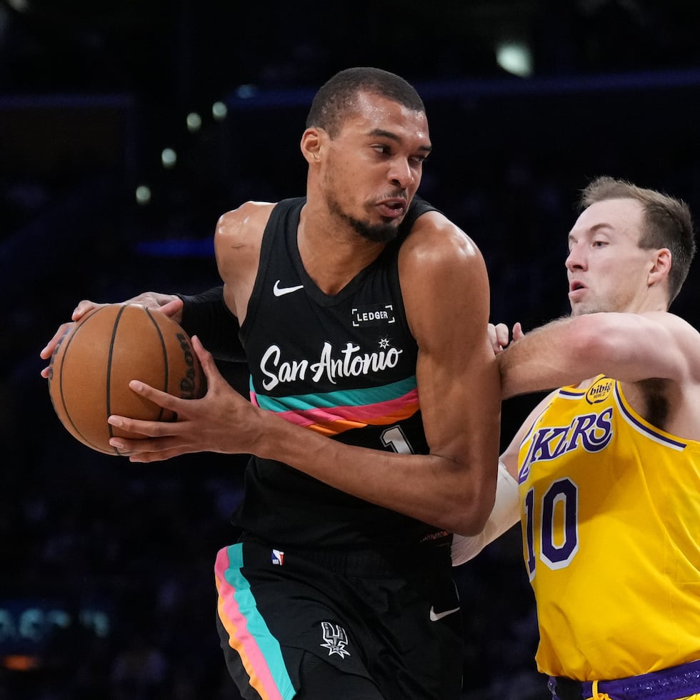 Victor Wembanyama busca ofensiva por los Spurs ante la defensa de Luke Kennard, de los Lakers.