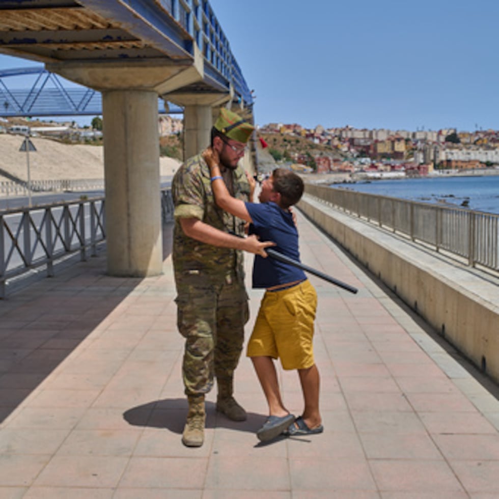 Un menor no acompañado de 12 años que cruzó a España es escoltado por un soldado español hasta la frontera entre España y Marruecos, mientras el niño suplica que no lo devuelvan a Marruecos desde el enclave español de Ceuta.