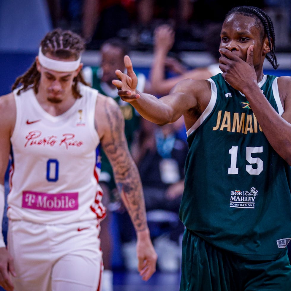 Romaine Thomas, de Jamaica, celebra un triple con Isaiah Piñeiro, de Puerto Rico, al fondo.