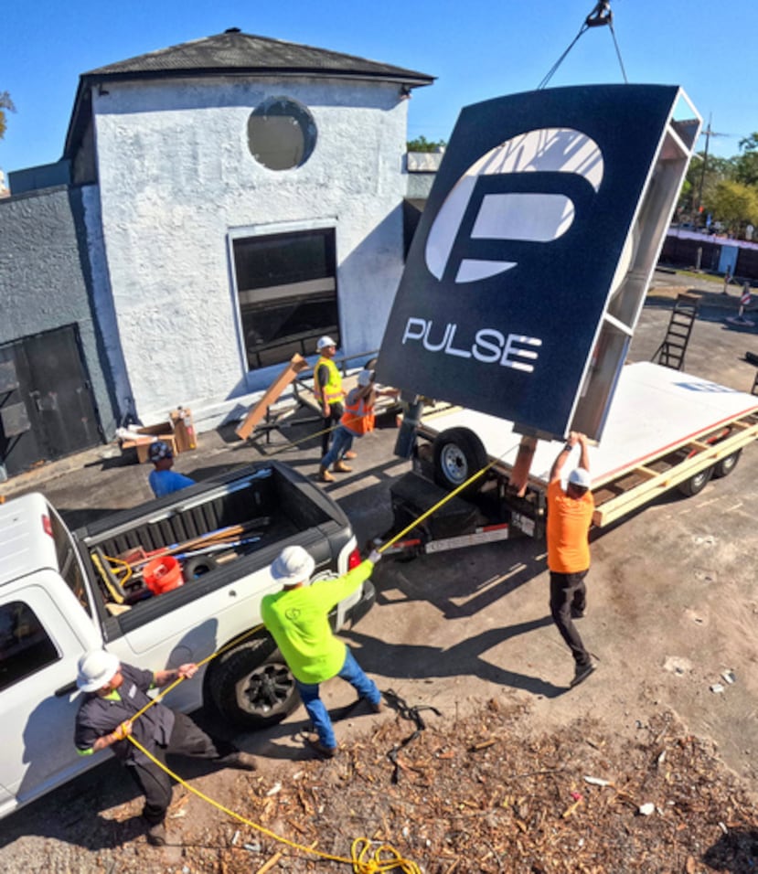 Trabajadores retiran el cartel de la discoteca Pulse, el miércoles 11 de marzo de 2026, en el monumento conmemorativo del tiroteo masivo de 2016 en Orlando, Florida, en el que murieron 49 personas. El cartel se conservará y se expondrá en el monumento permanente, cuya inauguración está prevista para otoño de 2027. (Joe Burbank/Orlando Sentinel vía AP)