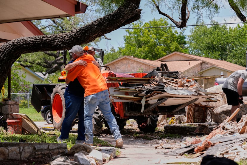 ARCHIVO - El propietario Daniel Olivas abraza a Lorrie McMillan, capellana de Texans on Mission Disaster Relief, mientras limpia los escombros de su casa, que sufrió graves daños por las inundaciones repentinas a lo largo del río Guadalupe en Kerrville, Texas, el 10 de julio de 2025. (Foto AP/Gerald Herbert, Archivo)