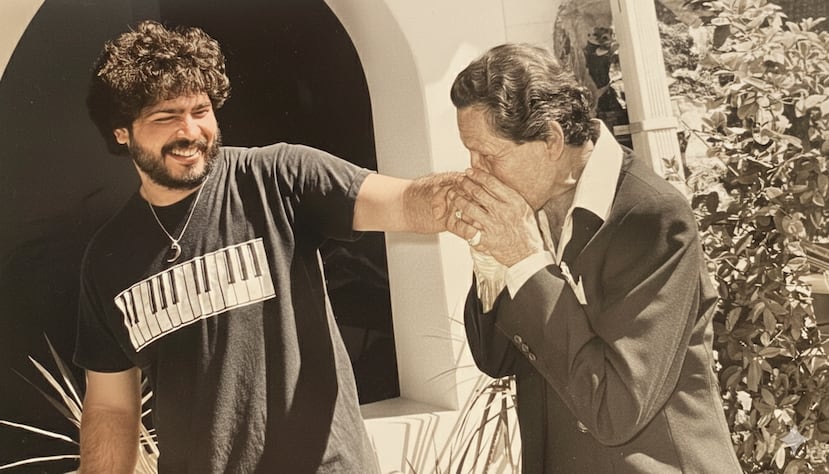 Gilberto Monroig, a la derecha, besa la mano de su hijo Glenn.