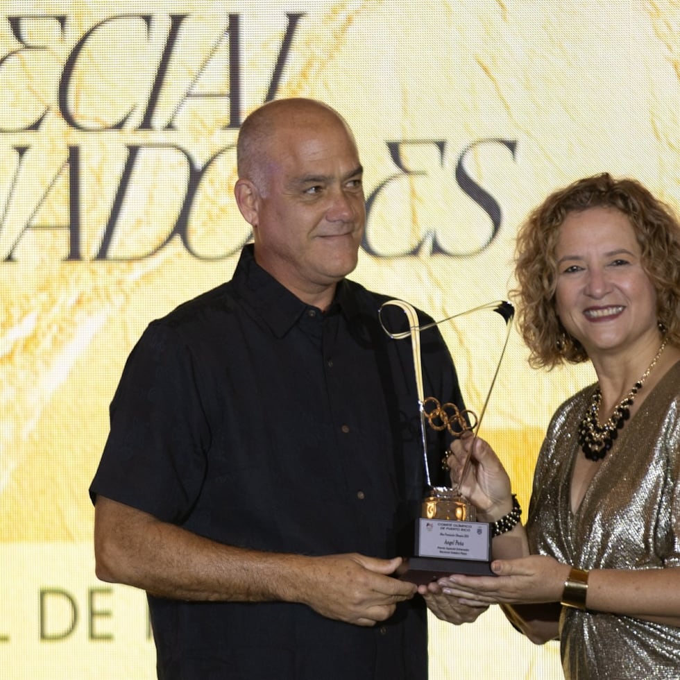 Ángel “Cholo” Peña recibe un reconocimiento por parte de la presidenta del Comité Olímpico de Puerto Rico, Sara Rosario.