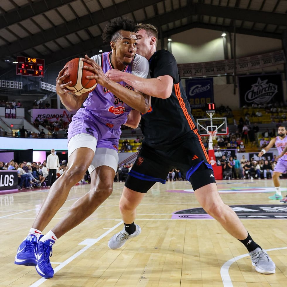 Moses Brown, de los Criollos, se dirige al canasto contra Viktor Lakhin, de los Cangrejeros.