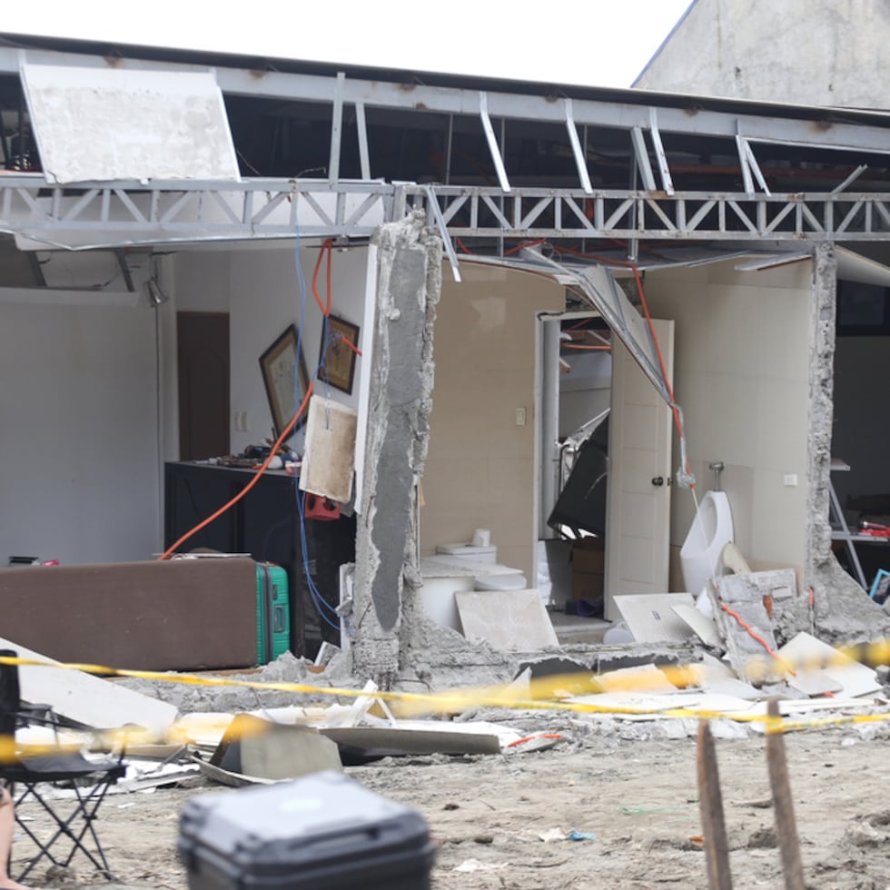 Residentes permanecen junto a una casa dañada tras un fuerte terremoto en la ciudad de Davao.