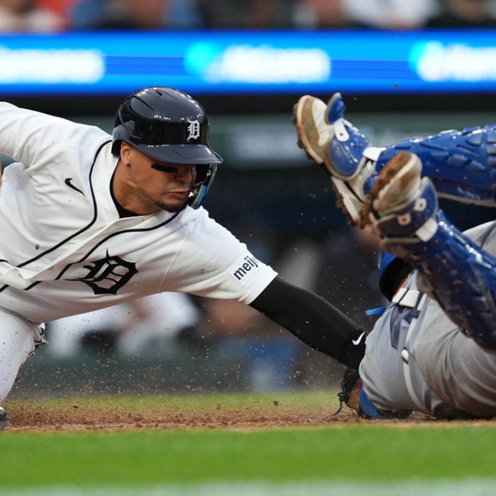 El boricua Javier Báez, a la izquierda, pisa el plato de forma segura antes del toque del receptor de los Royals Salvador Pérez, a la derecha, durante la tercera entrada.