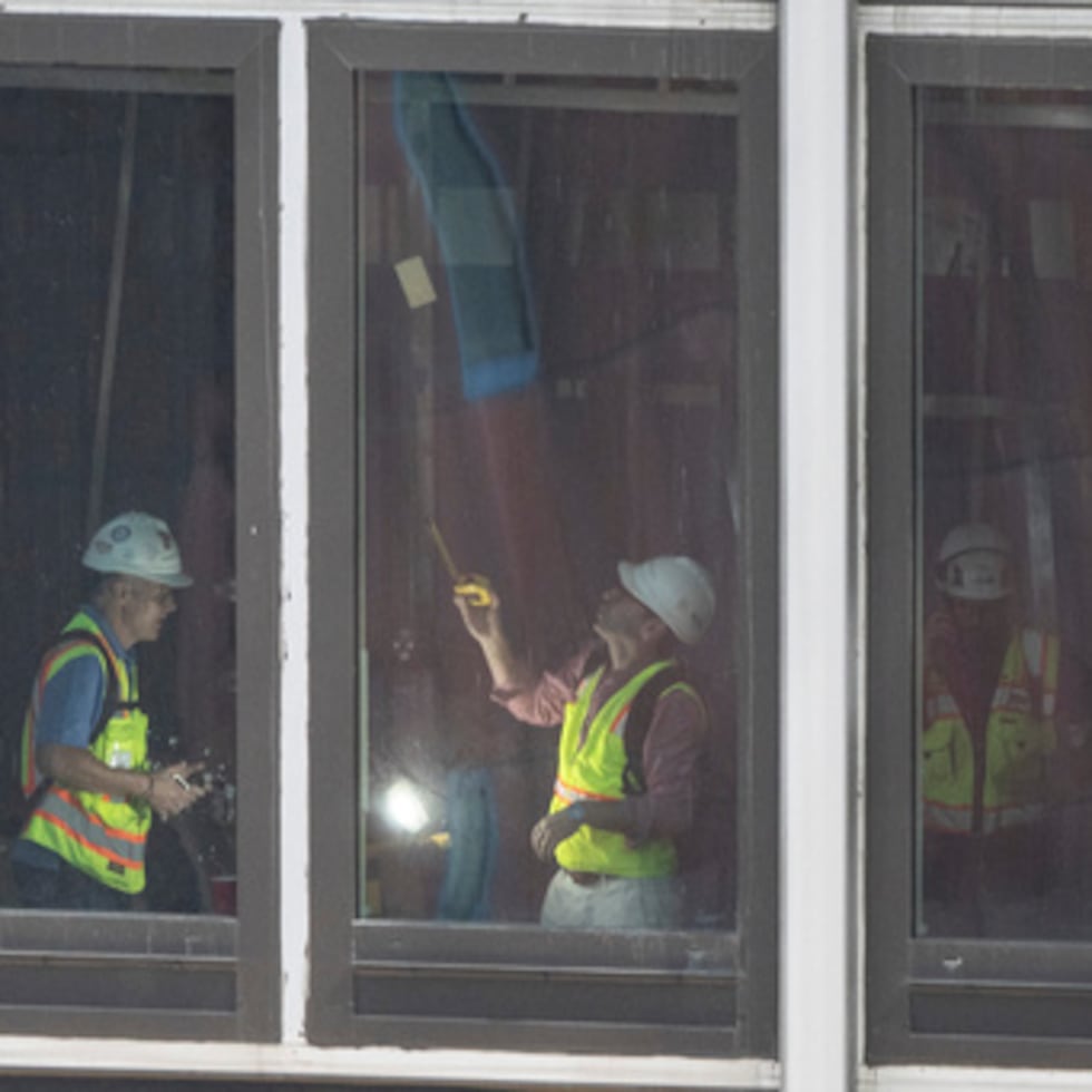 Varias personas inspeccionan una viga de soporte deformada en el interior del número 235 de la calle 42 Este.