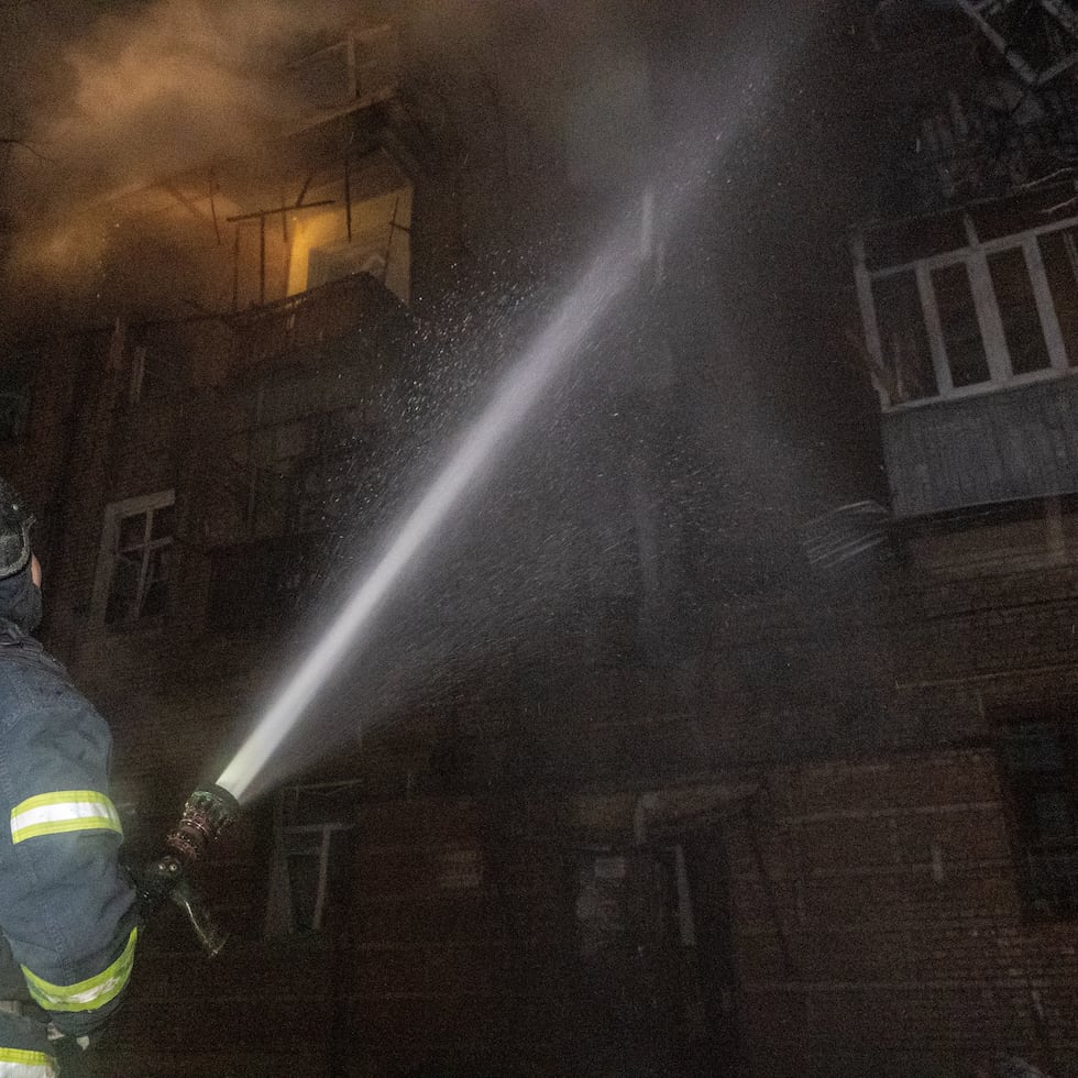 Efectivos de los servicios de emergencias tratan de apagar un incendio en un edificio tras una taque ruso en Járkiv, Ucrania.
