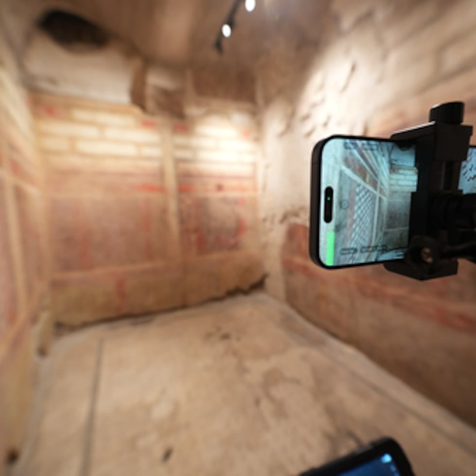 Valentina, guía del Parque Arqueológico del Coliseo, utiliza un dispositivo con montura en la cabeza para retransmitir en directo una visita guiada para la prensa a la recién restaurada Casa subterránea de los Grifos, datada entre los siglos II y I a.C., en la colina del Palatino, junto al Coliseo, en Roma, el martes 13 de enero de 2026. (AP Photo/Andrew Medichini)