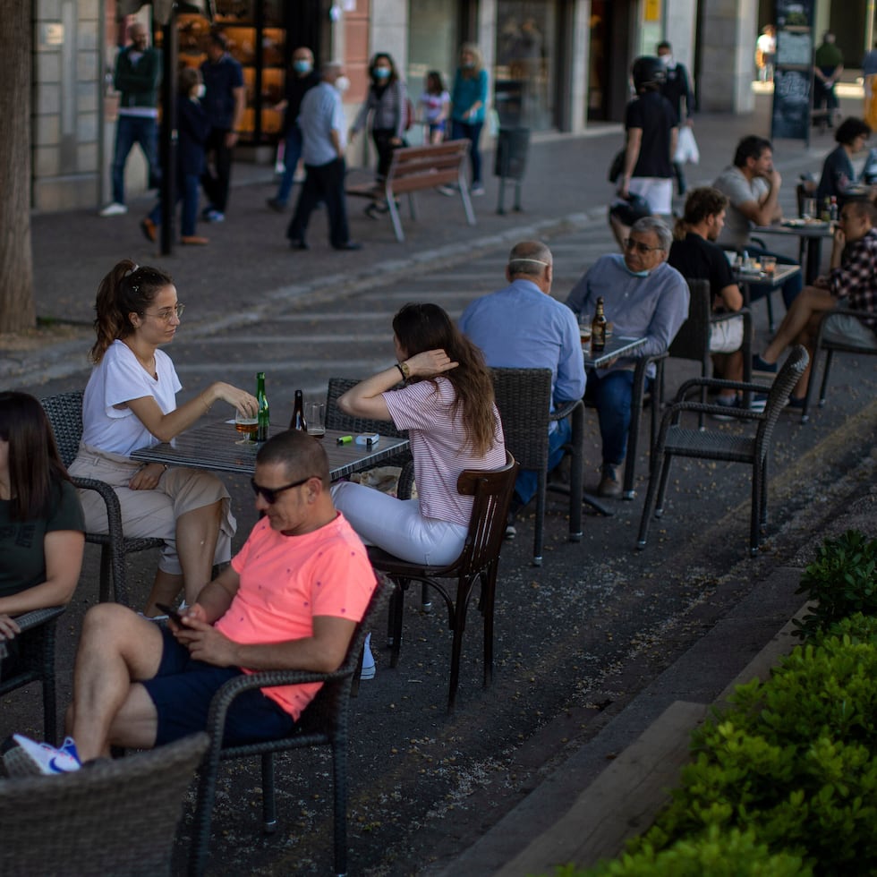 Clientes sentados en la terraza de un bar en Girona, España.