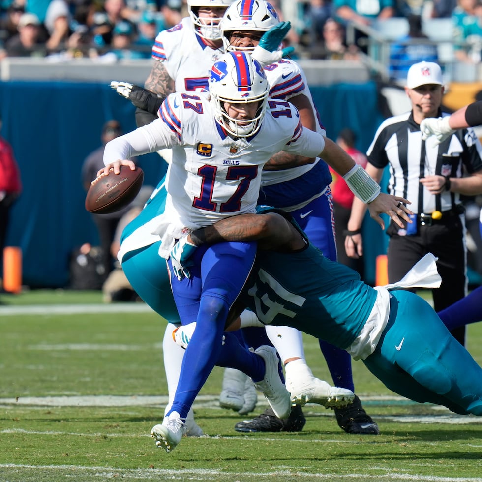 Josh Allen (17) es sostenido por Josh Hines-Allen (41) durante el partido entre Bills y Jaguars.