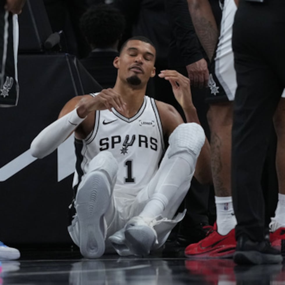 El alero de los San Antonio Spurs Victor Wembanyama (1) se sienta en la cancha tras una dura caída durante la primera mitad del segundo partido de la primera ronda de los playoffs de baloncesto de la NBA contra los Portland Trail Blazers en San Antonio, el martes 21 de abril de 2026.
