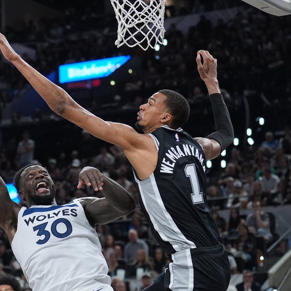 Victor Wembanyama, de los Spurs, intenta impedir que Julius Randle, de los Timberwolves, anote.