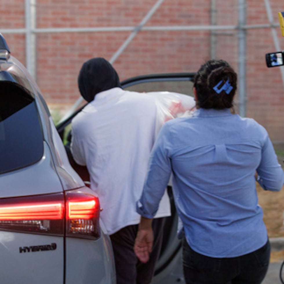 El agente de Inmigración y Aduanas Christian Castro se sube a un coche rodeado de periodistas momentos después de ser puesto en libertad del centro de detención Carrizalez-Rucker.