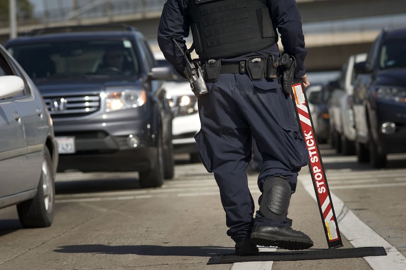 Un agente de la Oficina de Aduanas y Protección Fronteriza (CBP) de EE.UU. pasa entre el tráfico que se dirige a México, por el paso de San Ysidro (San Diego). (EFE/David Maung/Archivo)