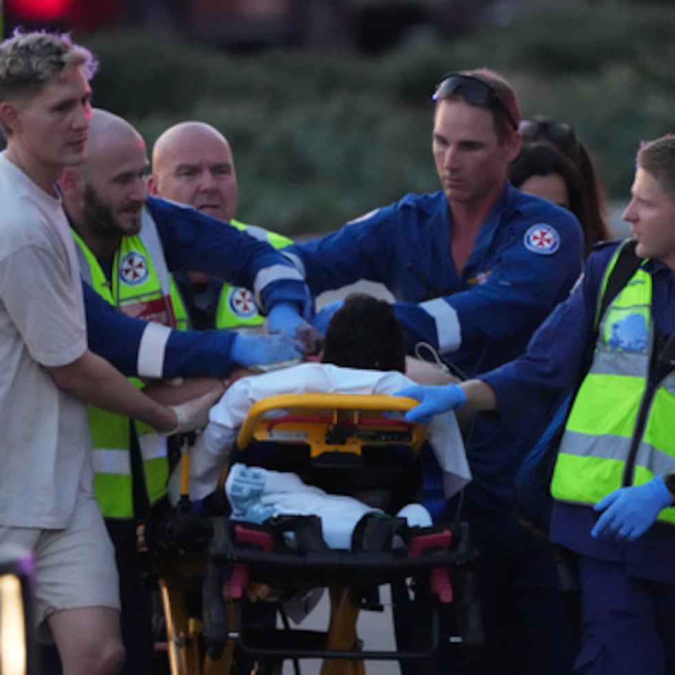 Trabajadores de emergencias transportan a una persona en camilla tras un tiroteo registrado en Bondi Beach, en Sídney.
