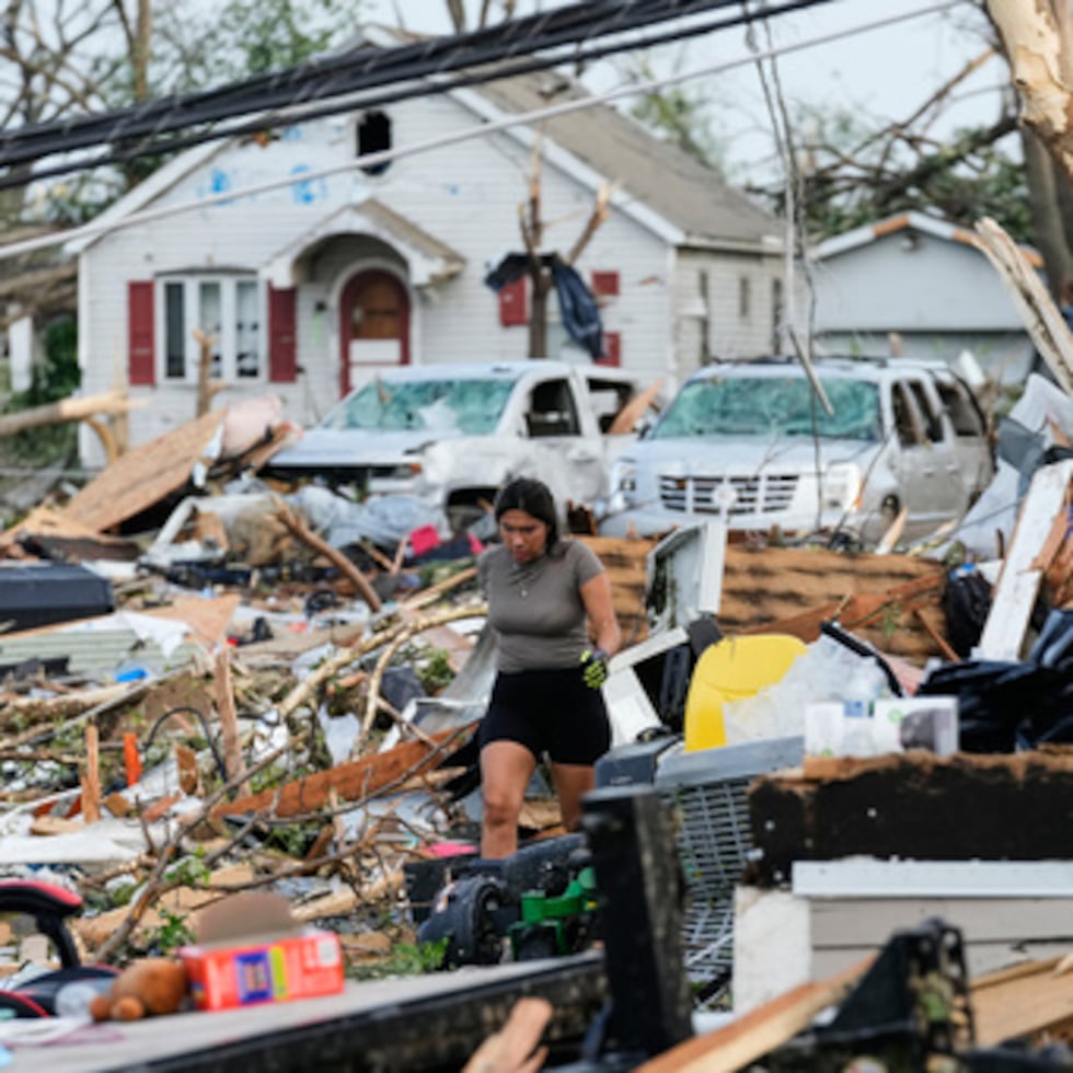 Una mujer camina entre los escombros tras el paso de un tornado el lunes 27 de julio de 2026 en Menasha, Wisconsin. (Foto AP/Kayla Wolf)