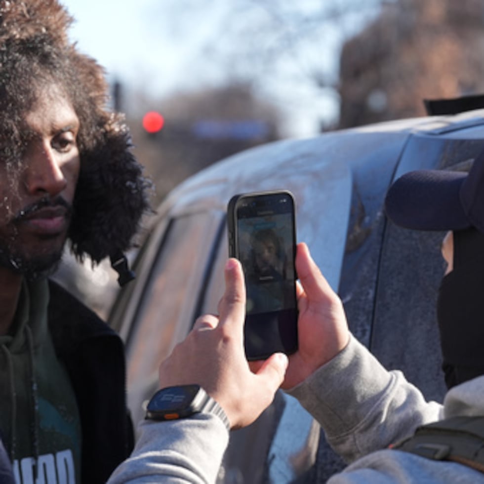 AÑADE UNA REFERENCIA A LA APP DE RECONOCIMIENTO FACIAL - Agentes federales utilizan una aplicación de reconocimiento facial en una persona detenida y posteriormente puesta en libertad el martes 27 de enero de 2026, en Minneapolis. (AP Photo/Adam Gray)
