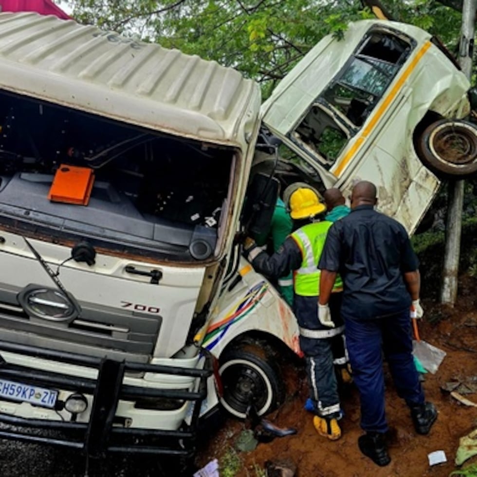 Personal de rescate inspecciona el lugar de una colisión en la que se vieron implicados un taxi minibús y un camión, cerca de Durban, Sudáfrica.