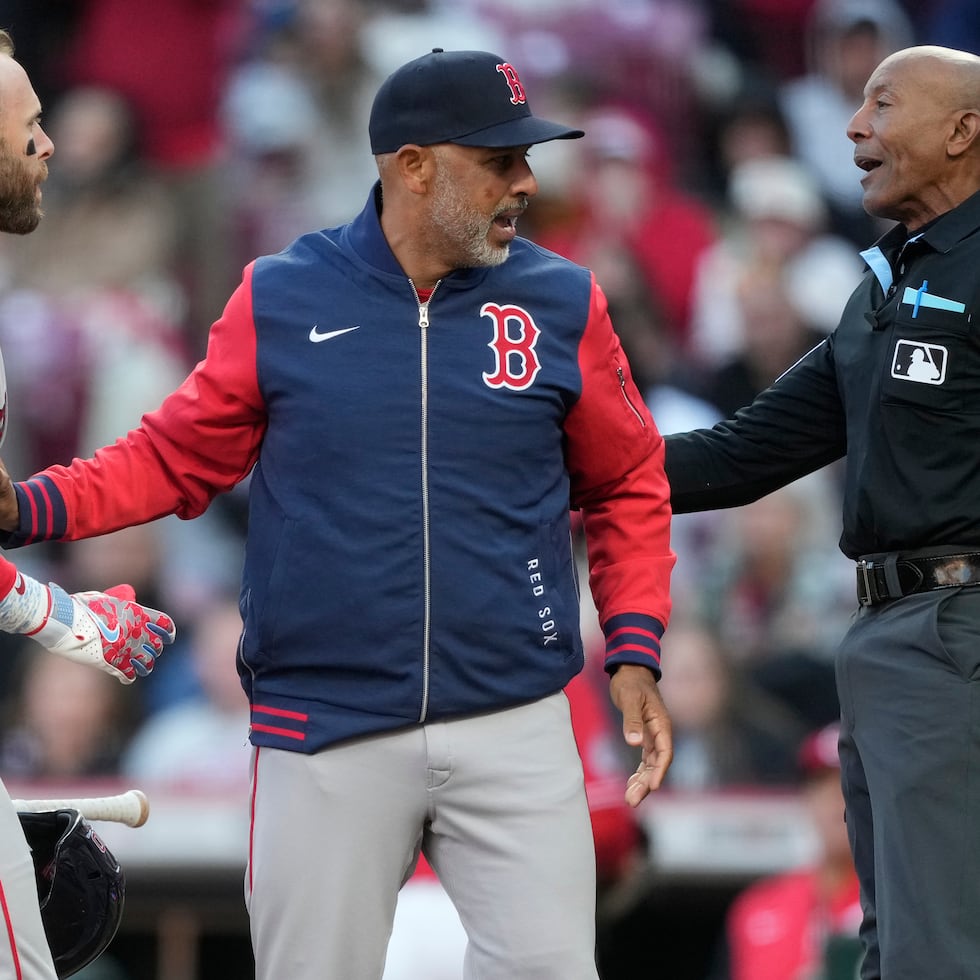El dirigente de los Red Sox Alex Cora, y el siore Trevor Story discuten una decisión del umpire del plato CB Bucknor antes de que el boricua fuera expulsado.