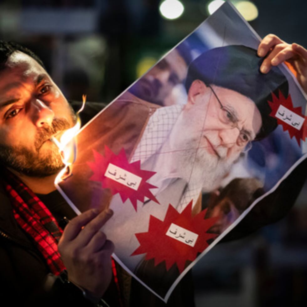 Un manifestante quema una imagen del ayatolá Ali Jamenei con un cigarrillo durante la manifestación en apoyo de las manifestaciones masivas a nivel nacional en Irán contra el gobierno, el martes 13 de enero de 2026 en Zuerich, Suiza.(Michael Buholzer /Keystone via AP)