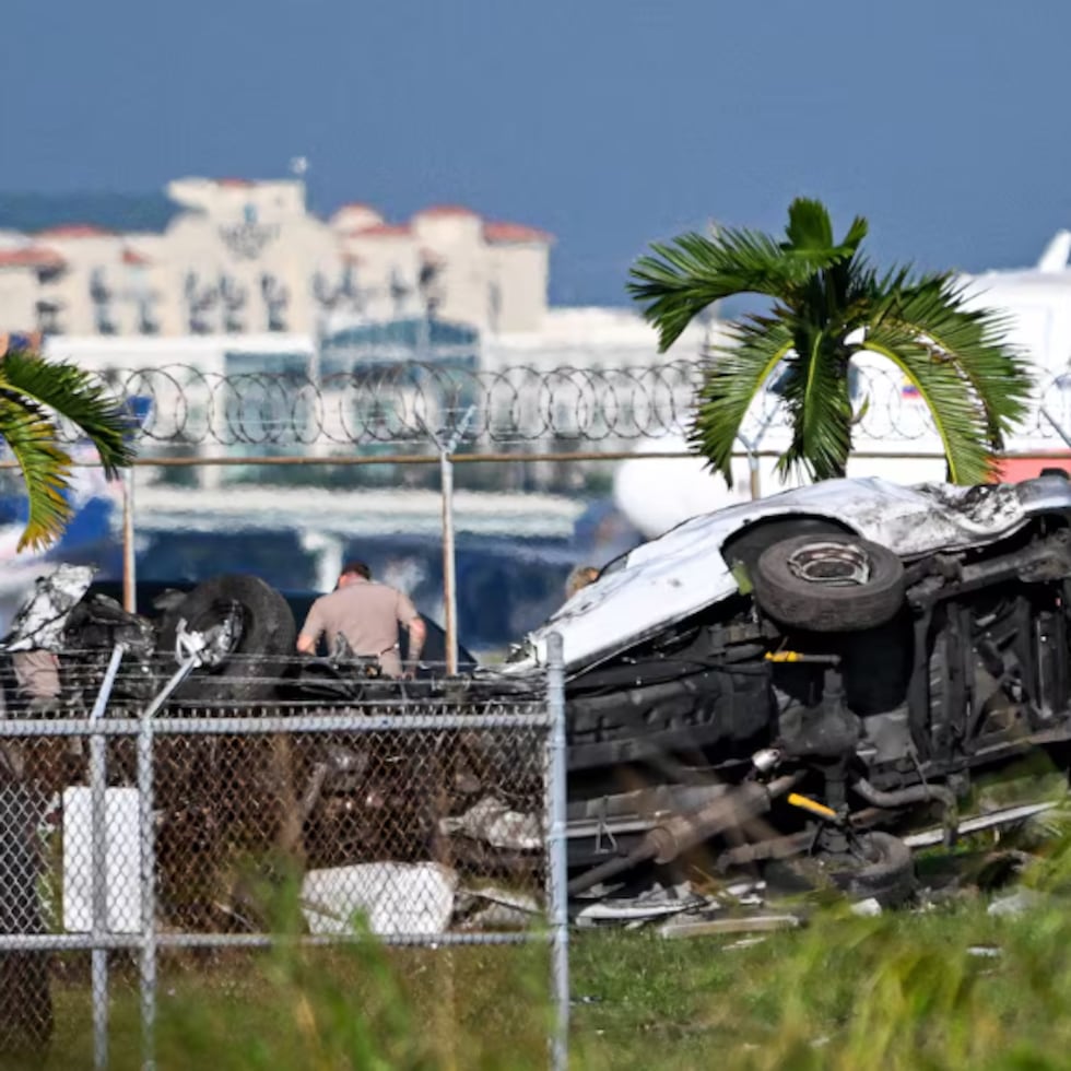 Funcionarios investigan el lugar donde varios vehículos resultaron dañados después de que un avión de carga de Prime Air se saliera de la pista y los embistiera en el Aeropuerto Internacional de Miami.