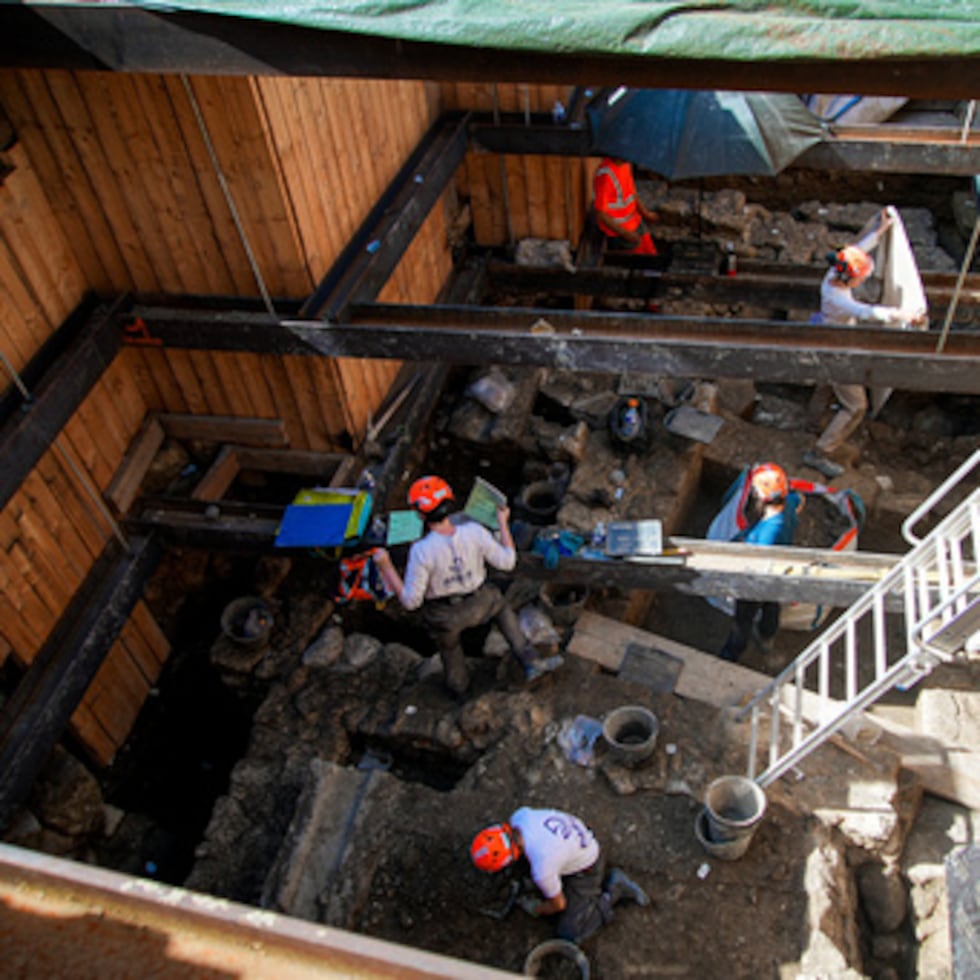 Arqueólogos equipados con cascos de obra excavan 13 pies bajon la tierra durante excavaciones en el exterior de la catedral de Notre Dame.