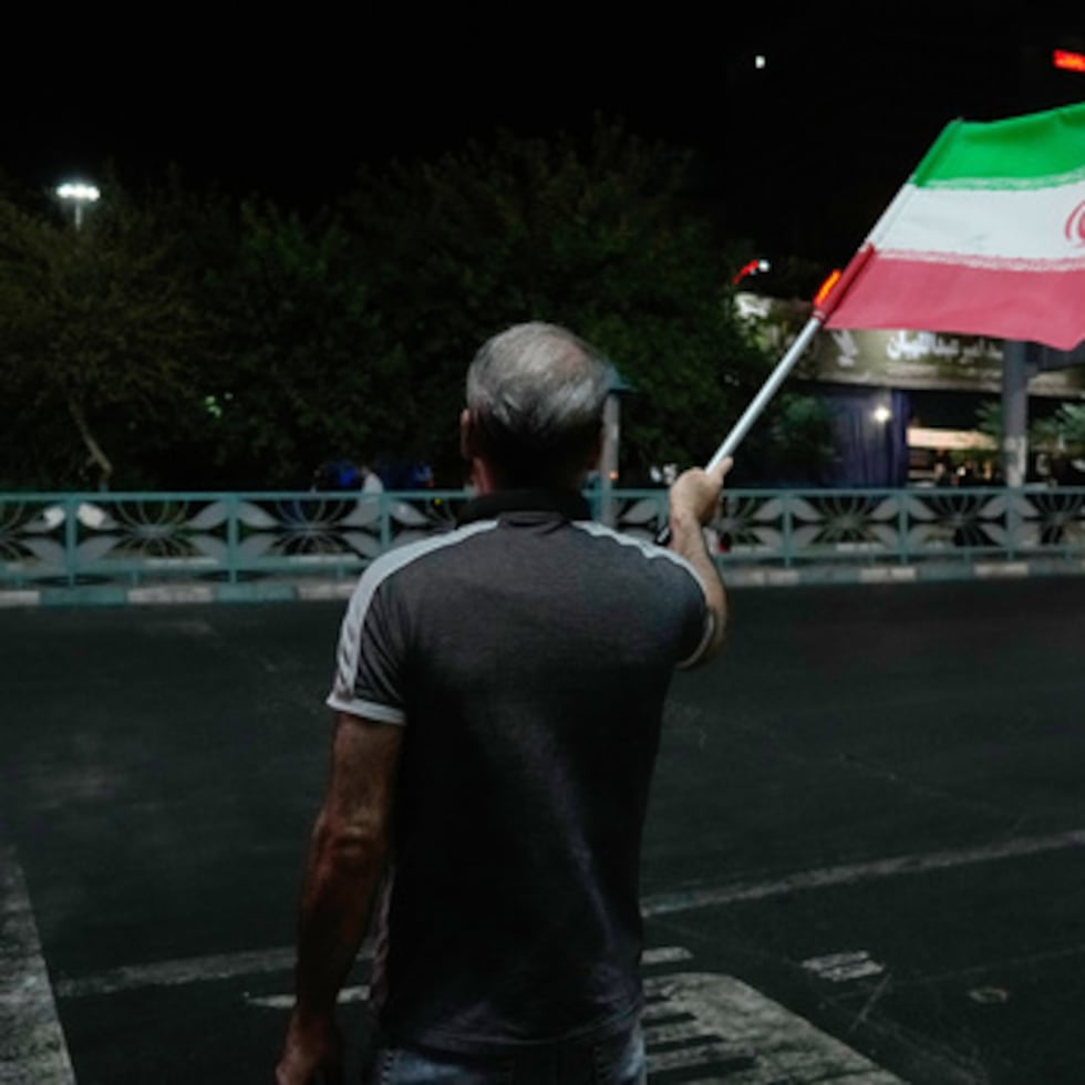 Un manifestante progubernamental ondea la bandera iraní durante una marcha en memoria del difunto líder supremo del país, el ayatolá Ali Jamenei.