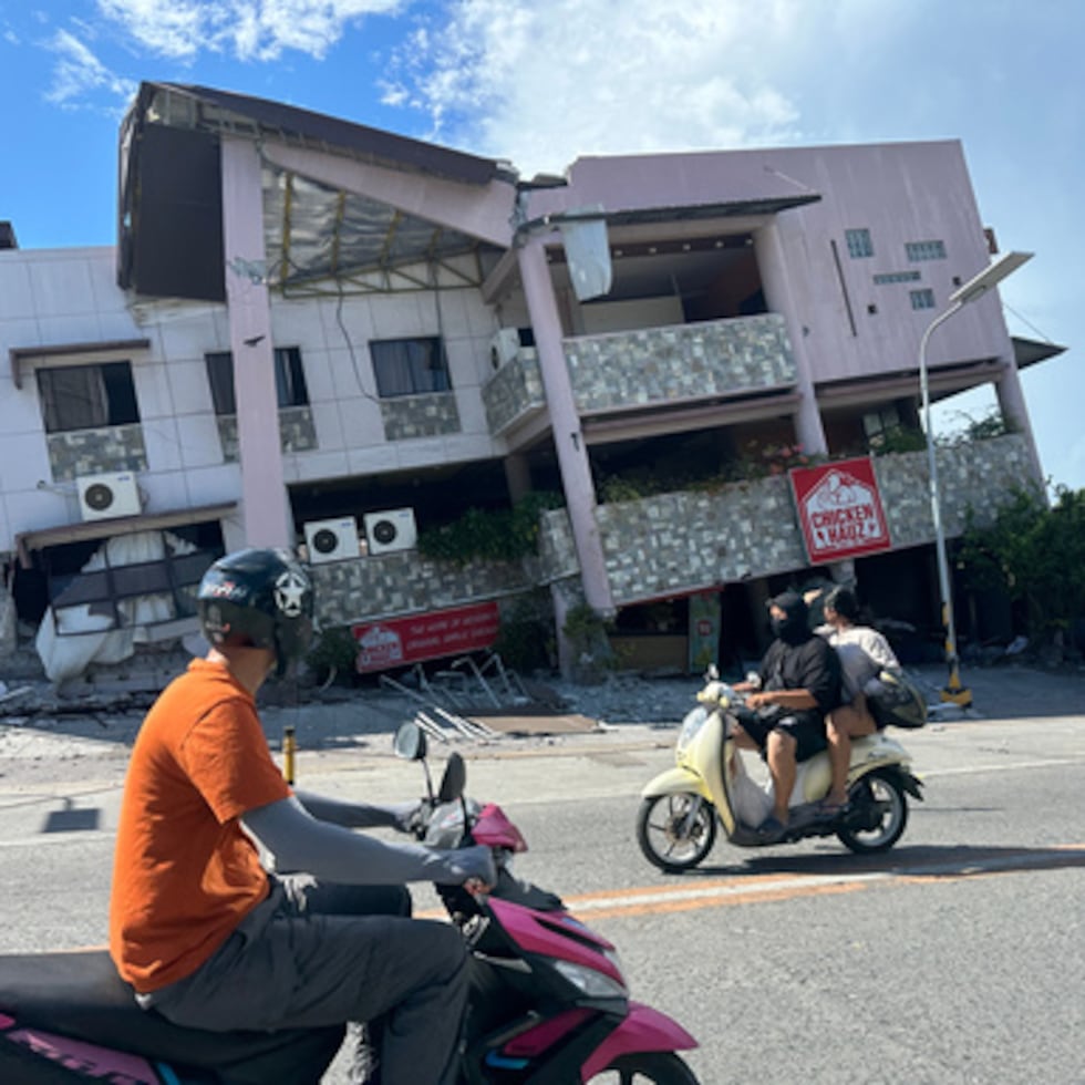 Residentes pasan junto a una estructura derrumbada tras un terremoto en General Santos, Filipinas.