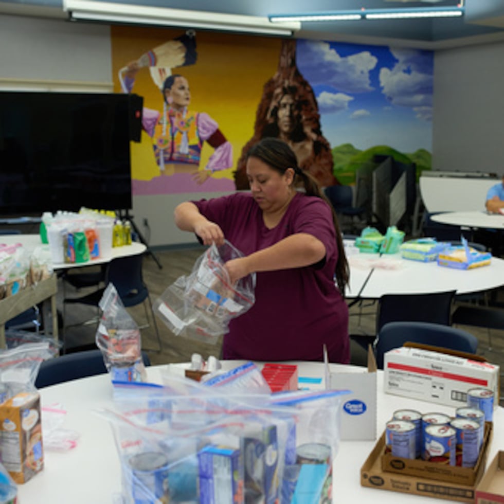 Carla Teran helps prepare bagged meals for a food bank for students at Nueta Hidatsa Sahnish College, Thursday, Oct. 30, 2025, in New Town, N.D. (AP Photo/John Locher)