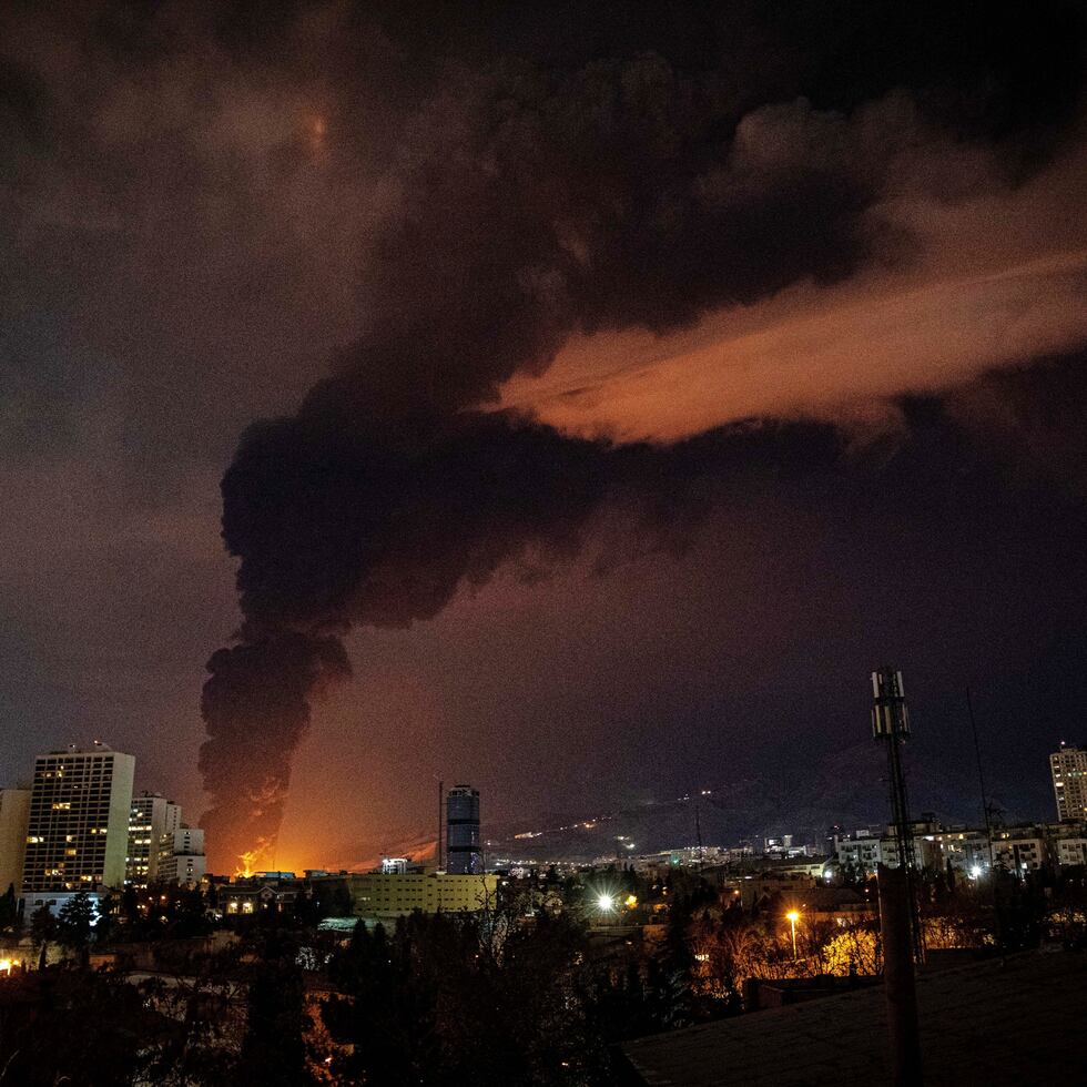 Llamas y humo salen de de una instalación de almacenaje de petróleo que fue impactada en Teherán, tras un ataque militar de Israel y Estados Unidos.