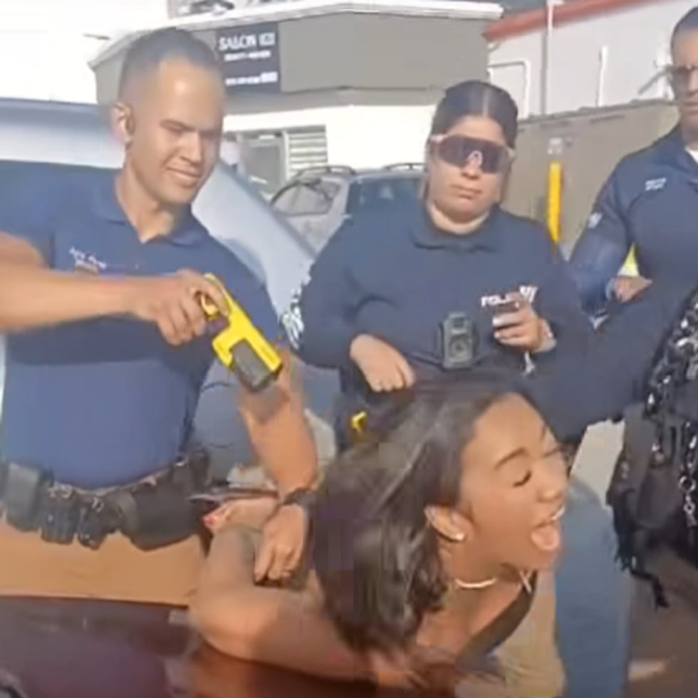 Captura del momento en que el agente le dispara con un taser a la mujer esposada.