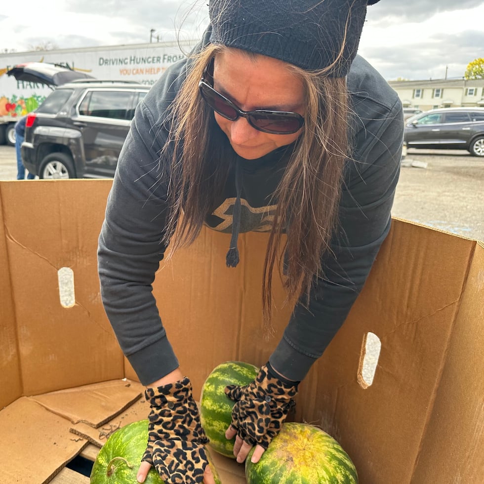 Una voluntaria organiza sandías en un contenedor durante un evento de distribución de alimentos de Forgotten Harvest celebrado en la Iglesia Bíblica Woodside, el viernes 24 de octubre de 2025, en Pontiac, Michigan.