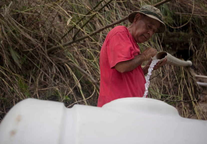 José Rodríguez es parte de una de las cientos de familias que acuden al sector El Chorro, en la carretera 142 hacia Corozal, para tomar agua de los chorros de un manantial cercano. (Teresa Canino / GFR Media)
