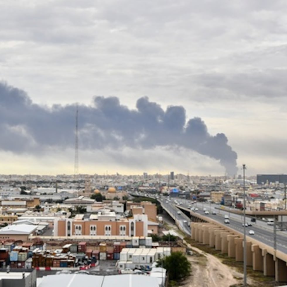 El humo se eleva desde el aeropuerto internacional de Kuwait después de un ataque con drones en el almacenamiento de combustible en la ciudad de Kuwait.