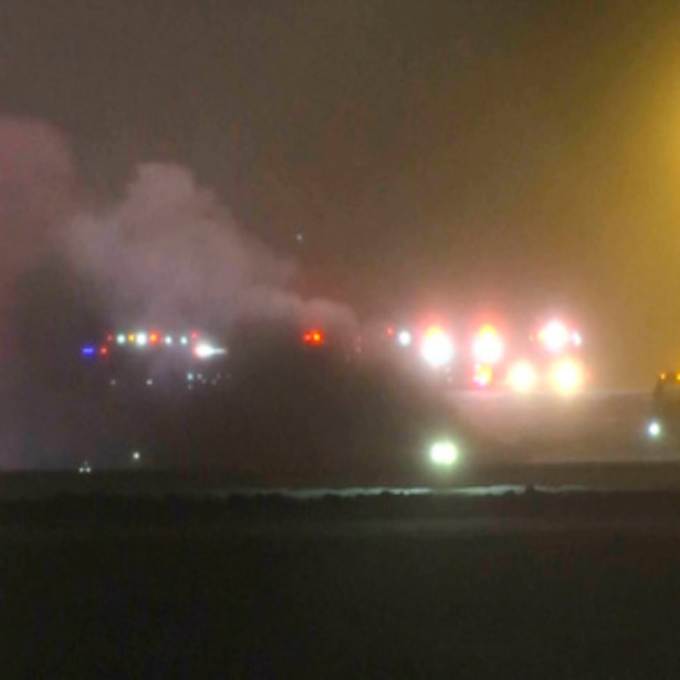 Esta imagen tomada de un video de la televisora WABI muestra a los servicios de emergencia trabajando en el lugar donde se estrelló un avión Bombardier Challenger 600 en el aeropuerto Bangor de Maine, la noche del domingo 25 de enero de 2026. (WABI via AP)