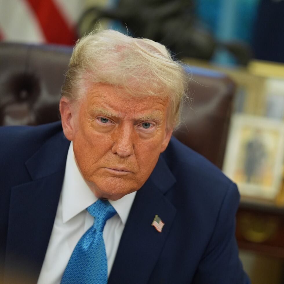 President Donald Trump speaks to reporters as he signs executive orders in the Oval Office of the White House.