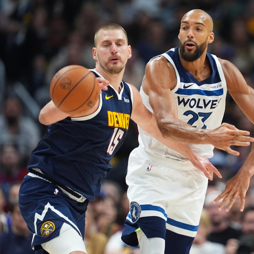 El pívot de los Nuggets, Nikola Jokic (izquierda), lucha por el control del balón con el centro de los Timberwolves, Rudy Gobert, en la segunda mitad del Juego 5 de una serie de primera ronda de los playoffs de la NBA.