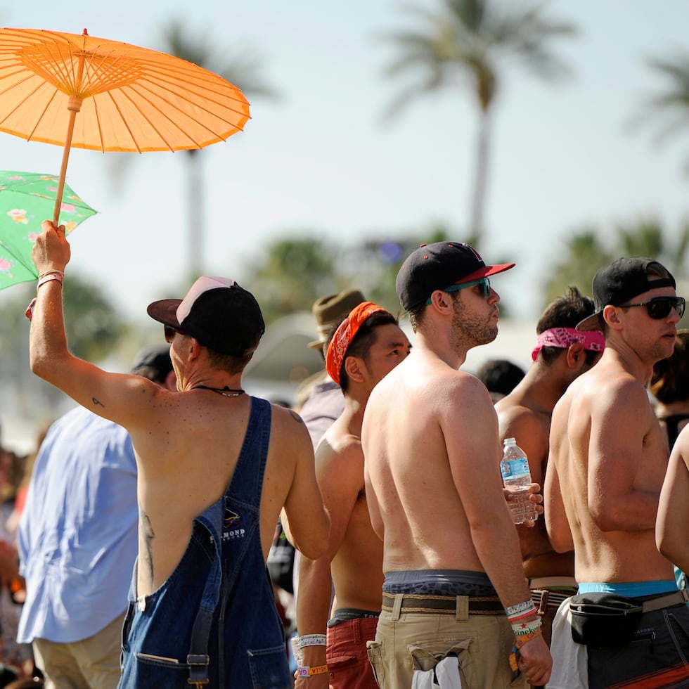 Asistente al festival de música Coachella en Indio, Califormia se protege del sol.