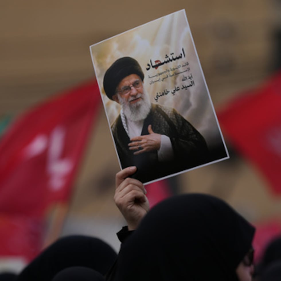 Un partidario de Hezbollah sostiene un retrato del fallecido líder supremo iraní, el ayatolá Alí Jamenei, en una marcha en un suburbio sureño de Beirut, Líbano, el domingo 1 de marzo de 2026. El texto en árabe en el retrato dice "Martirio del líder de la revolución islámica en Irán, ayatolá Alí Jamenei".