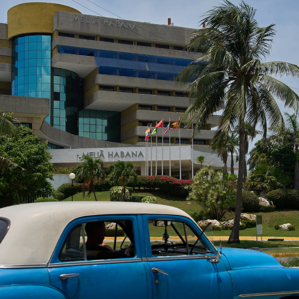 Un coche antiguo pasa frente al Hotel Meliá Habana en La Habana, Cuba.