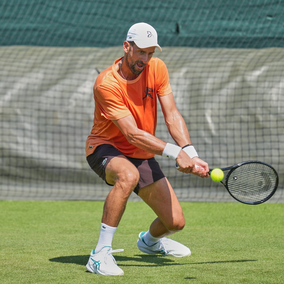 El serbio Novak Djokovic regresa una bola durante una sesión de práctica antes del inicio del torneo de Wimbledon.