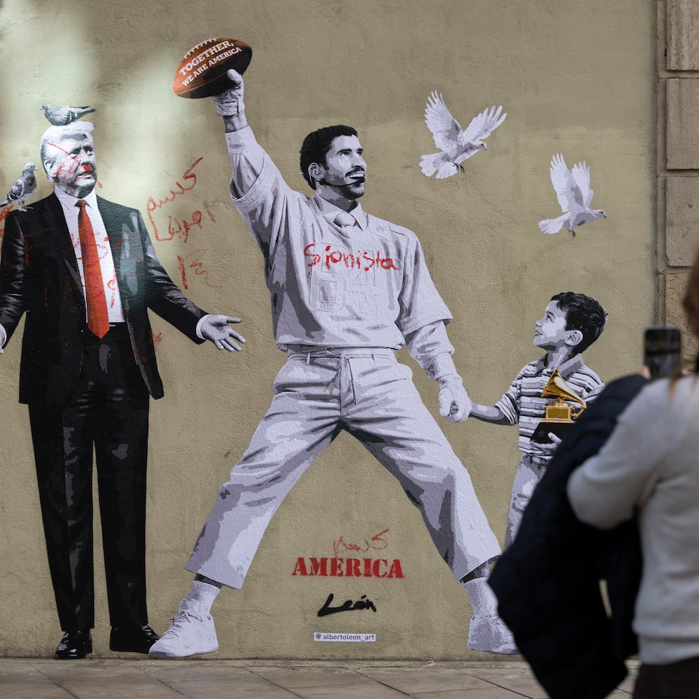 Un grafiti del artista Alberto León en el centro de Barcelona reivindica la paz frente al presidente estadounidense, Donald Trump, con una imagen del cantante puertorriqueño Bad Bunny en su espectáculo de la Super Bowl, de la mano de un niño detenido por la policía migratoria. EFE/ Marta Perez