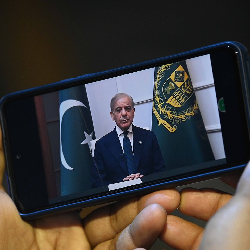 Una persona sostiene un teléfono que muestra un discurso del primer ministro pakistaní, Shehbaz Sharif, a la nación en Karachi, Pakistán, el 10 de abril de 2026. Se espera que Islamabad reciba a delegaciones de alto nivel de Estados Unidos e Irán, y las negociaciones están programadas para comenzar el 11 de abril. Las conversaciones se producen tras un acuerdo de alto el fuego de dos semanas mediado por Pakistán.