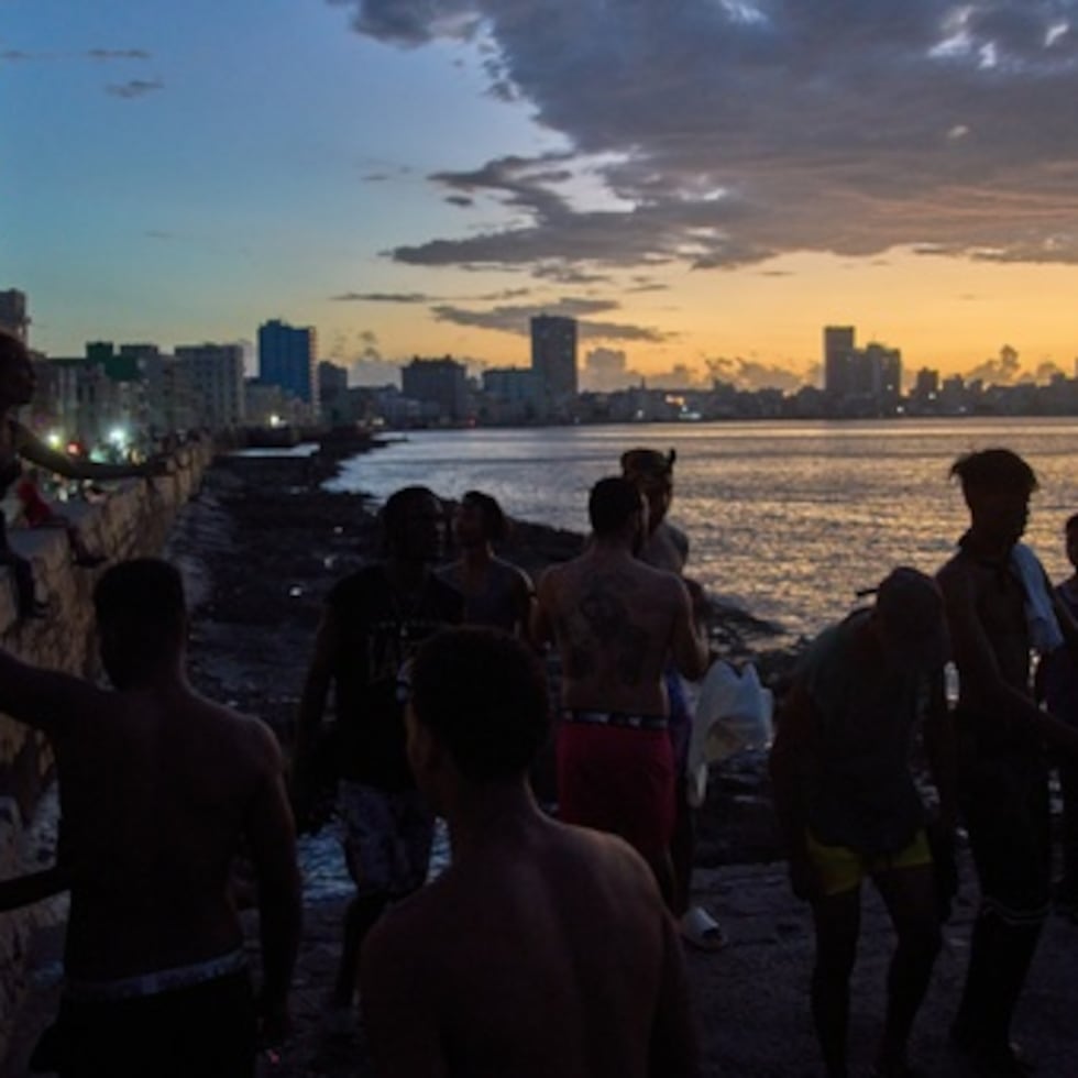 La gente observa la puesta de sol desde el Malecón durante un apagón en La Habana, el lunes 16 de marzo de 2026. (AP Photo/Ramon Espinosa)