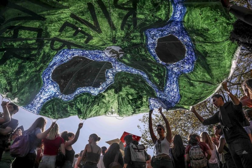 Los activistas del cambio climático ponen una pancarta por los ríos de la tierra durante una manifestación en Nueva York. (Foto AP / Bebeto Matthews)