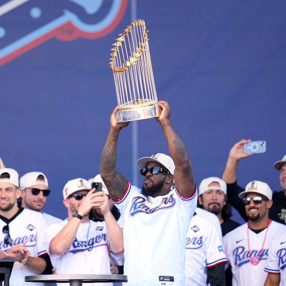 El cubano Adolis García, con el rodeado de sus compañeros de los Rangers de Texas mientras alza el Trofeo del Comisionado, bateó este año para .227 con 19 jonrones y 75 carreras impulsadas.