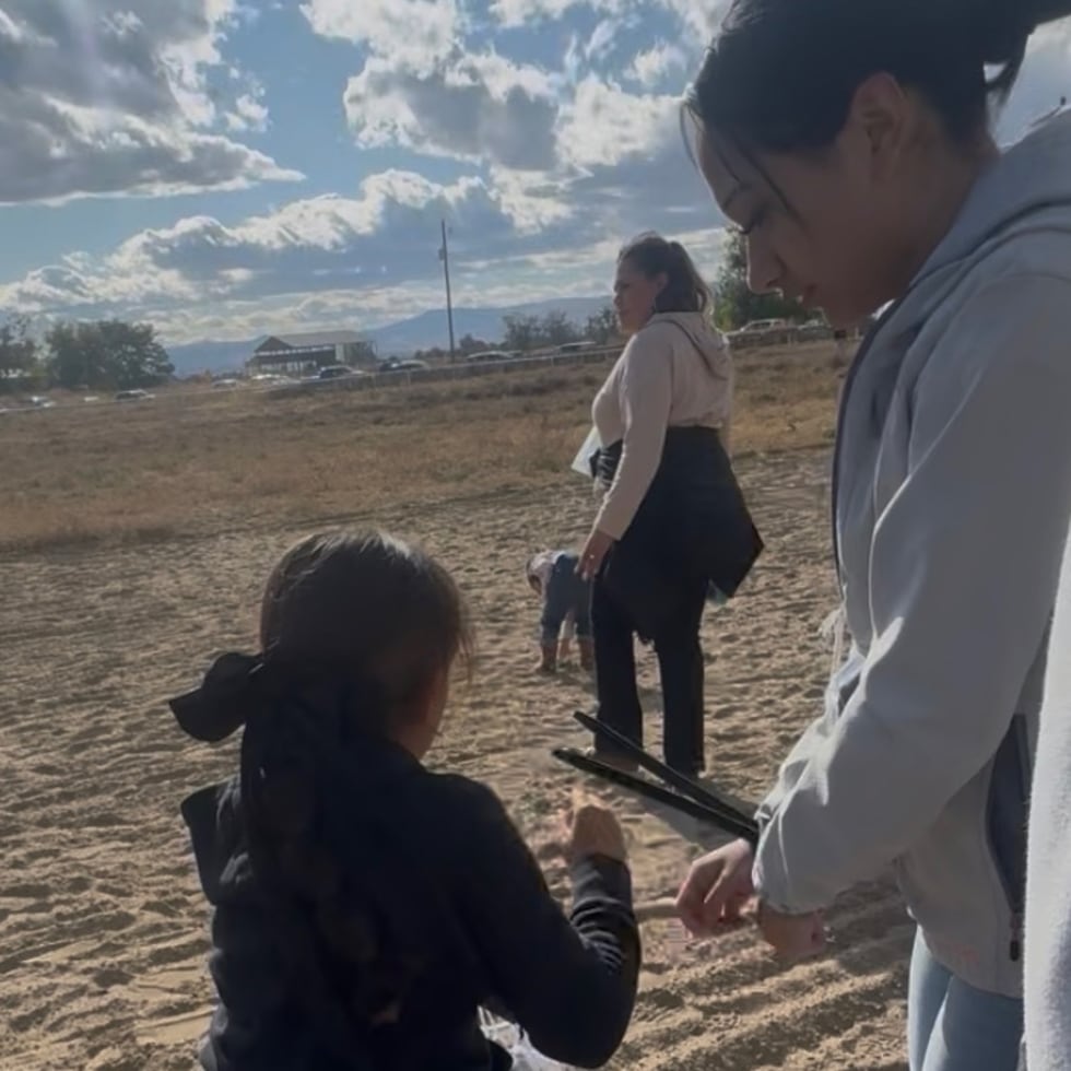 Esta foto, provista por Anabel Romero, muestra a su hija de 14 años (a la derecha), con las manos sujetas con bridas plásticas, junto a su hija de 8 años (en el centro, en primer plano), durante una redada realizada por varias agencias del orden público en el hipódromo La Catedral Arena, en Wilder, Idaho.
