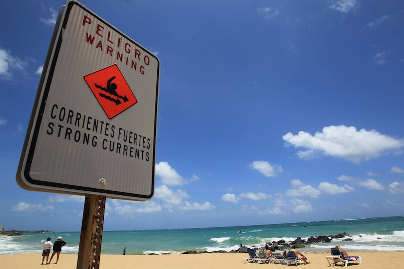 Letrero que advierte de corrientes marinas fuertes en la costa.