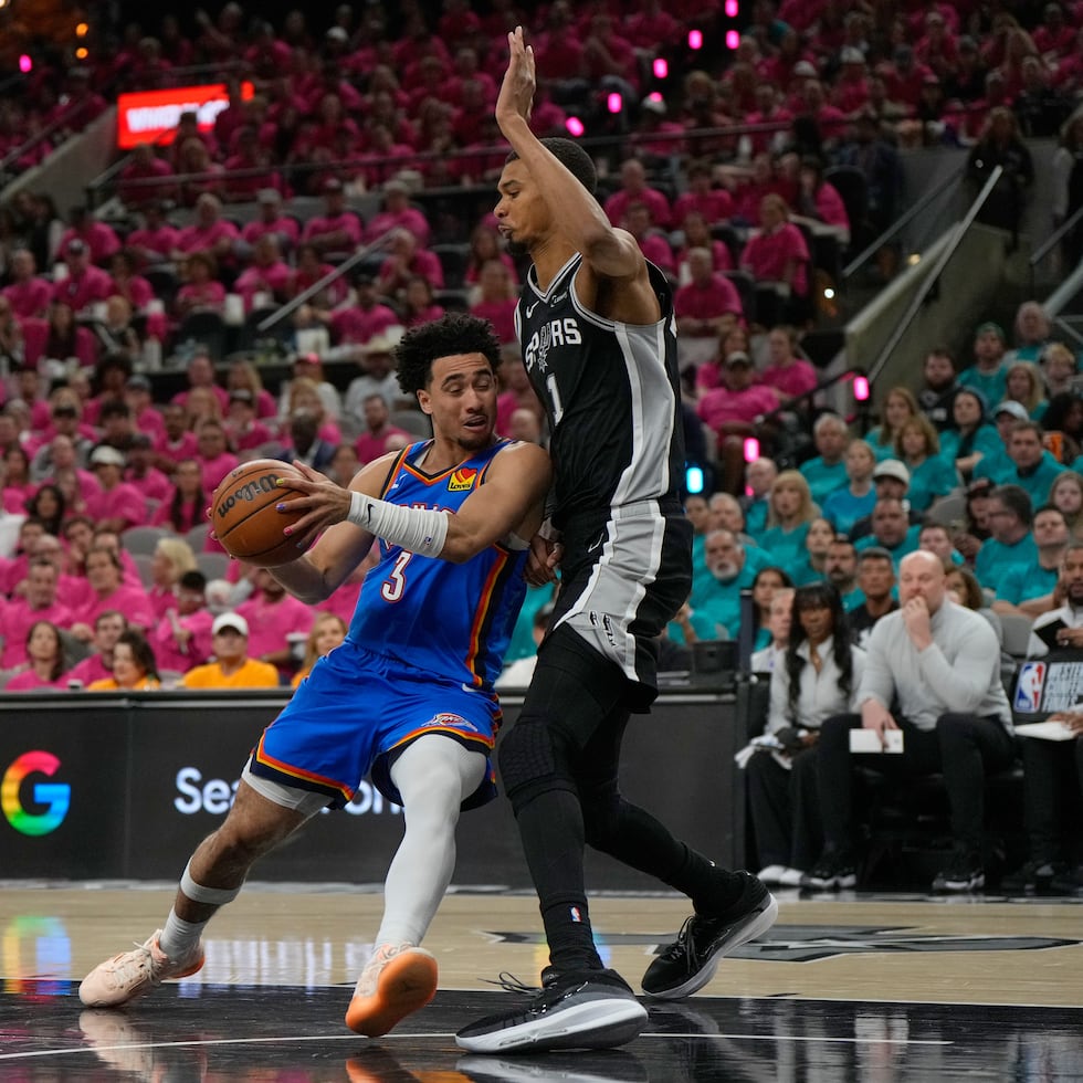Jared McCain (3), reserva de Thunder, busca llegar al canasto contra Victor Wembanyama, de los Spurs.
